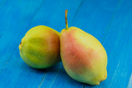 Two ripe pearls on blue wooden background. selective focus.の写真素材