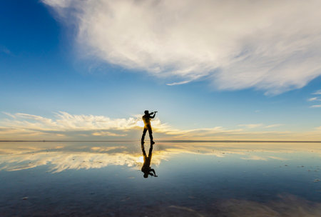 Silhouette of a man at sunset on the salt lake.の写真素材