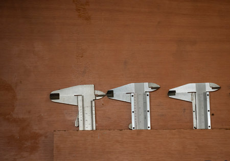Vernier calipers on a wooden background with copy space.