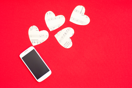 A cell phone with paper hearts making a love messageの写真素材
