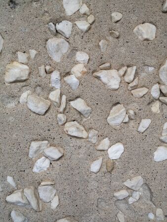 A lot of large white pebbles in porous gray concrete, textureの写真素材