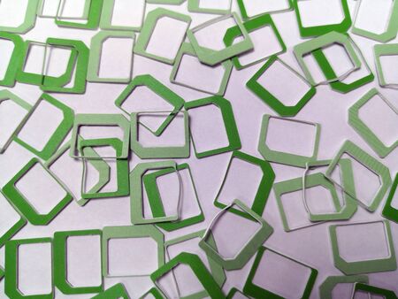 A lot of green plastic SIM frames lying on a white background, textureの写真素材