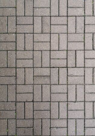 Gray square paving slabs with small cracks photographed in the daytime, texture, backgroundの写真素材