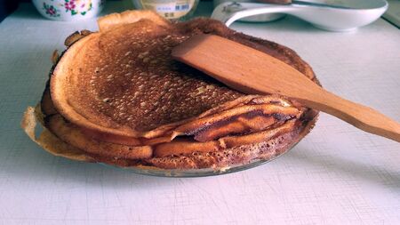 Pancakes and a kitchen shoulder blade on a transparent plateの写真素材