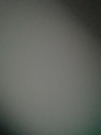 Background from a gray gradient, with accent darkening on the lower left and upper right cornersの写真素材