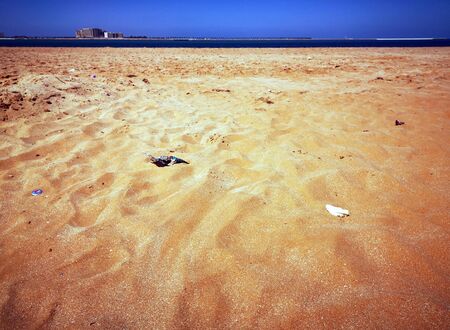 Garbage scattered on a golden sandy beach, ecologyの写真素材