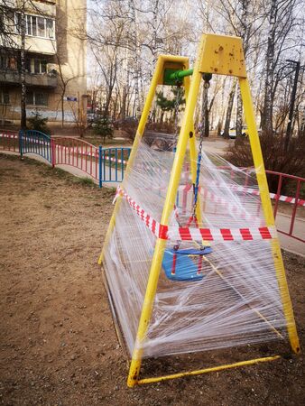 An empty colorful playground in a park is sealed. The sports complex is quarantined. Coronavirus or Covid19.の写真素材