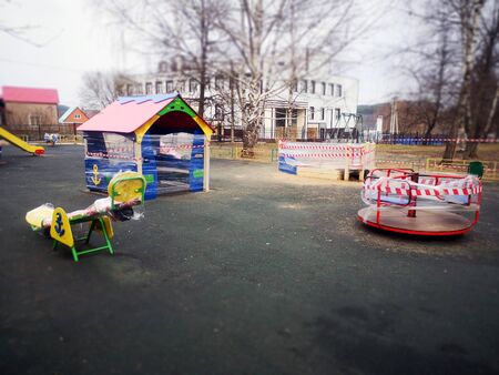 An empty colorful playground in a park is sealed. The sports complex is quarantined. Coronavirus or Covid19.の写真素材