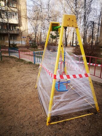 An empty colorful playground in a park is sealed. The sports complex is quarantined. Coronavirus or Covid19.の写真素材