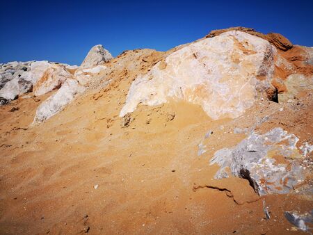 Big stones on the sea coast with white sand beach, bay, sea and blue sky. Beach, wildlife.の写真素材