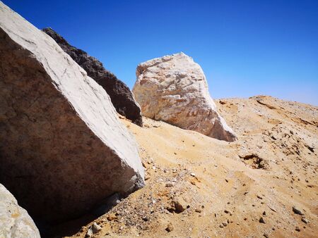 Big stones on the sea coast with white sand beach, bay, sea and blue sky. Beach, wildlife.の写真素材