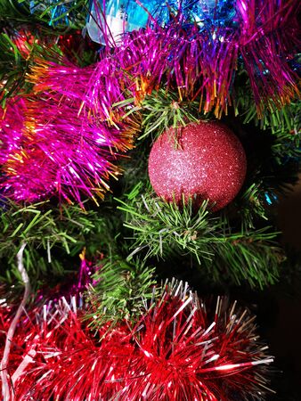 Christmas tree decorated with glittering toys shines beautifully with colorful lightsの写真素材