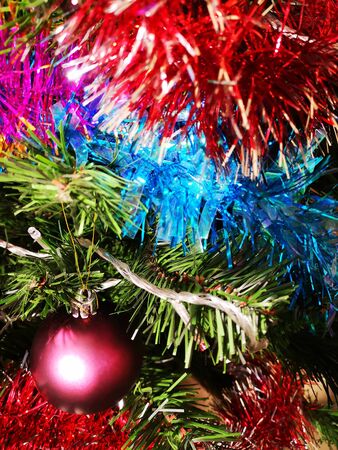 Christmas tree decorated with glittering toys shines beautifully with colorful lightsの写真素材