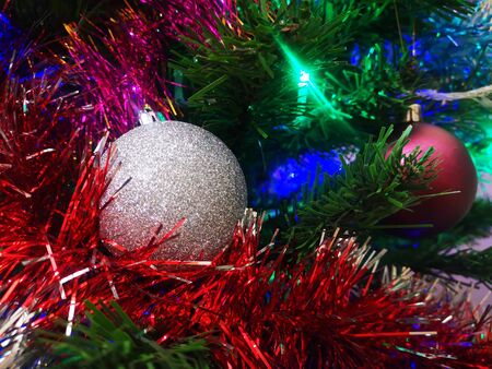 Christmas tree decorated with glittering toys shines beautifully with colorful lightsの写真素材