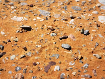 Fine golden coastal sand on which lies small pebbles, summer