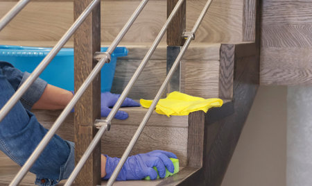 Woman in rubber gloves wash laminate stairs in house. Cleaning and cleanliness, detergents. . High...