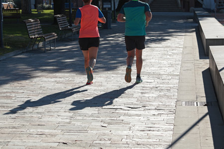People running in park near in Liguria, Sister Levante, Italy. Silhouette and sunlight. Nature and...
