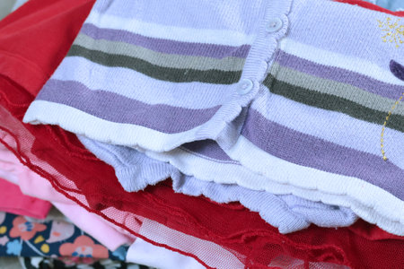 Stack of baby clothes in pink colors. Cleaning and recycling. Ecology and upcycle. High quality...