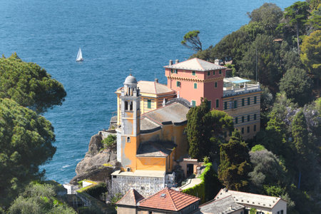 Portofino, Italy - 07 April 2025. Yachts, church in bay of Liguria. Sea and tourism in Italy. Traditional buildings. Background for design. High quality photoの写真素材