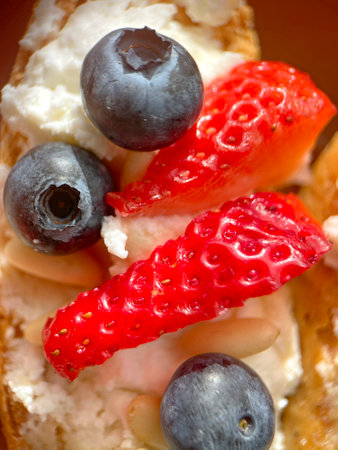 Crostini with ricotta, berries, pine nuts. Slices of toasted bread with cheese for breakfast. A healthy meal and snack. High quality photoの写真素材