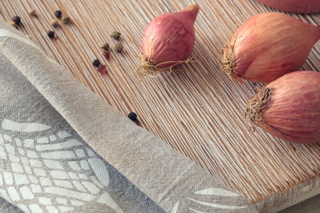 Shallots on wooden cutting board. Food and cooking. Healthy eating and organic products. High...