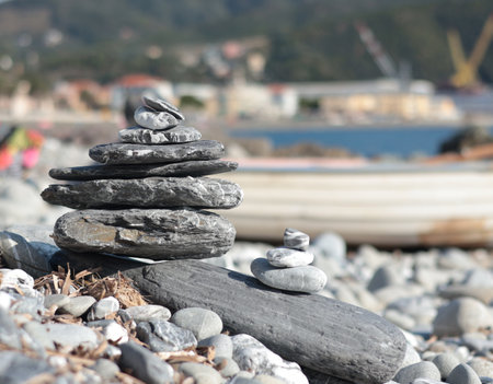 Big and small pyramid of marble stones against mountain backdrop on sunny day. Balance of mental health and meditation. Caring for body.の写真素材