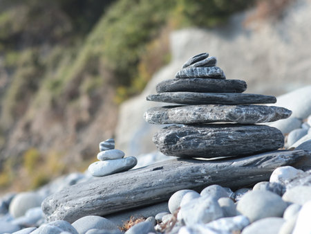 Big and small pyramid of marble stones against mountain backdrop on sunny day. Balance of mental health and meditation. Caring for body. High quality photoの写真素材