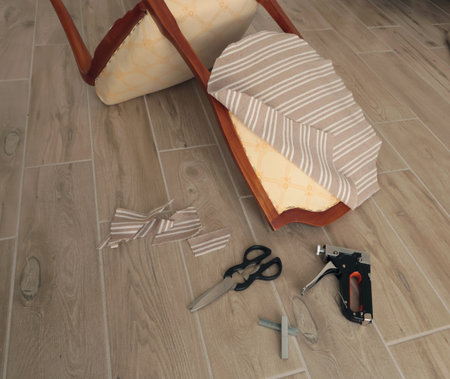 Restore old vintage chair in home. Fabric replacement. Antique furniture and modern striped linen and cotton fabric. Hobbies, crafts, and retro-minimalist style. High quality photoの写真素材