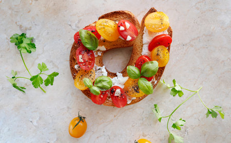 Round bruschetta with red and yellow cherry tomatoes and goat cheese on marble board. Farm produce,...