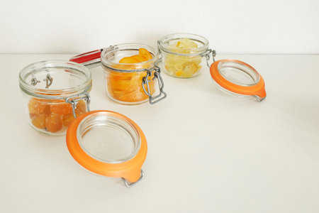 Preparing candied citrus fruits for jars. Sweets and traditional food. Kumquats, orange peels, and...