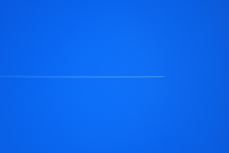 Aircraft across the blue skyの写真素材