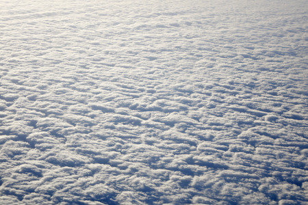 Sky and fluffy clouds taken from airplane window at sunriseの写真素材