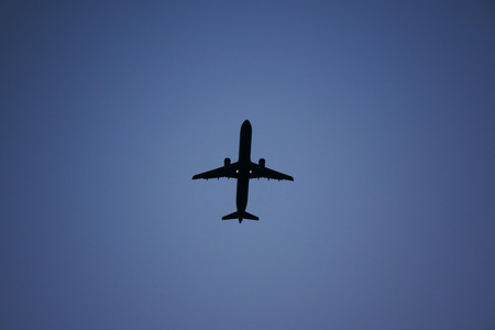 Silhouette of airplane in the blue sky at night