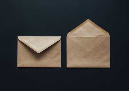 Two kraft postal envelopes on a black background. The layout of the envelope template is made of brown kraft paper. Flat lay.の写真素材