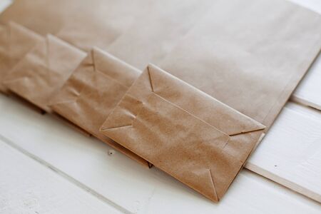 Paper bags on light wooden floor. Simple brown paper bags for lunch or meal. The layout for the...