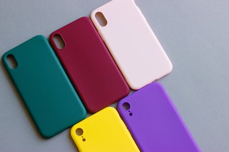Set of colored silicone cases for the smartphone on the grey background.