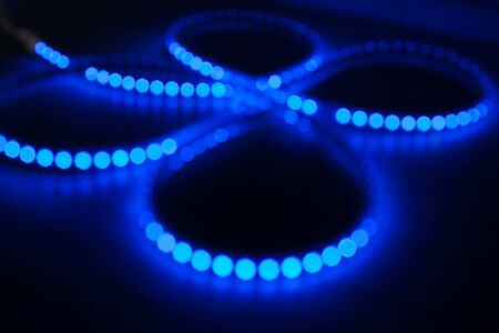 Diode strip. Led lights tape close-up. Glitter bokeh blue. Colorful Christmas illumination. Christmas and New year glowing abstract bokeh light and blurred background. The concept of the Christmas and holiday season.の写真素材