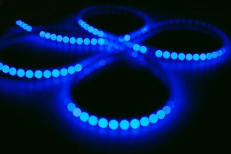 Diode strip. Led lights tape close-up. Real fire with blurred effect or bokeh style. Colorful Christmas illumination. Christmas and New year glowing abstract bokeh light and blurred background. The concept of the Christmas and holiday season.の写真素材