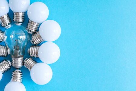 Lamps, LED lamps and fluorescent lamps on blue background. Large set of LED bulbs. White energy-saving light bulbs. Light bulbs lie in a row.の写真素材