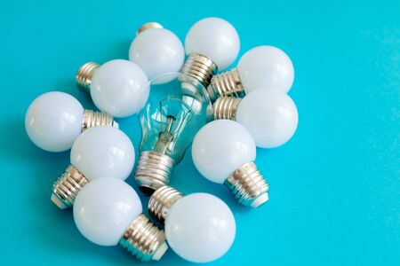 Lamps, LED lamps and fluorescent lamps on blue background. Large set of LED bulbs. White energy-saving light bulbs. Light bulbs lie in a row.の写真素材