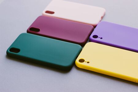Set of colored silicone cases for the smartphone on the grey background. Protection for the back cover of the mobile phone with a slot for the camera.の写真素材