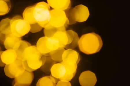 A beautiful image of a bokeh from New Year's garlands. In gold colors. Defocused glitter lighting...