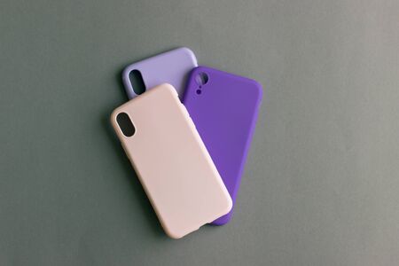 Pink, lilac and purple cases for the smartphone on the grey background. Protective silicone cases for smartphone. Colorful silicone cases for your smartphone.の写真素材