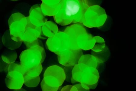 A beautiful image of a bokeh from New Year's garlands. In green neon colors. Defocused glitter...