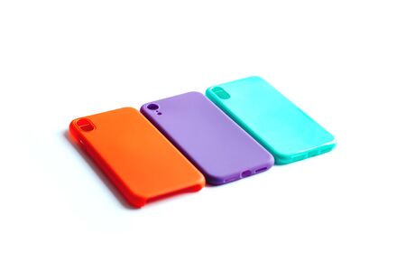 Mint, orange and purple cases for the smartphone on the white background. Protective silicone cases for smartphone. Colorful silicone cases for your smartphone. Isolated image, selective focus.の写真素材