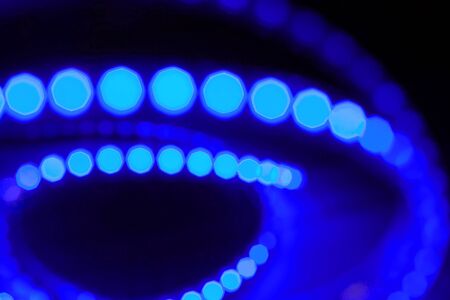 Diode strip. Led lights tape close-up. Real fire with blurred effect or bokeh style. Colorful Christmas illumination. Christmas and New year glowing abstract bokeh light and blurred background. The concept of the Christmas and holiday season.の写真素材
