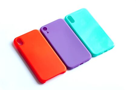 Mint, red and purple cases for the smartphone on the white background. Protective silicone cases for smartphone. Colorful silicone cases for your smartphone. Isolated image, selective focus.の写真素材