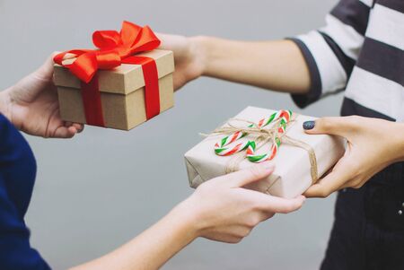 Girls exchange beautiful Christmas gifts. New year gift. Gift for Christmas, birthday, Valentine's day. Selective focus.の写真素材