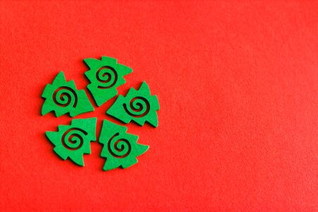 Small green wooden Christmas trees. Christmas trees for decoration. Wooden Christmas trees on a red background. Christmas background. Selective focus.の写真素材