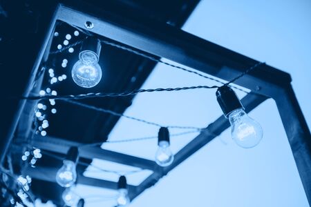 Decorative garland of light bulbs. Wedding decor, light bulbs on a wooden frame. Decoration of the...